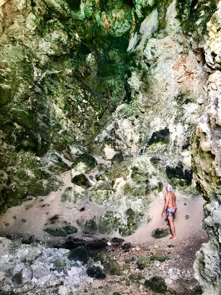 One of the guest inside the cave of Little Bay, watching at the white and green colors of the rocks. 