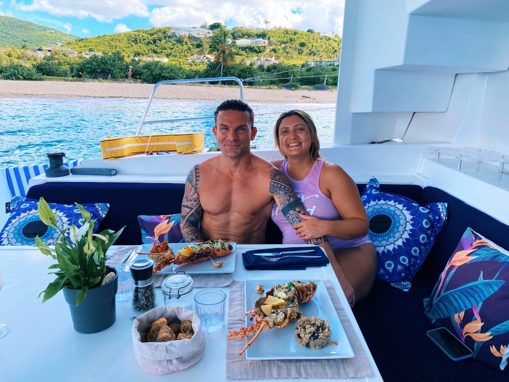 Couple enjoying a private lunch in Happy Bay with fresh Lobster & wild mushroom risotto as the main course.