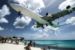 Flight landing at St Martin main airport (SXM) as seen from the famous beach of Maho Beach