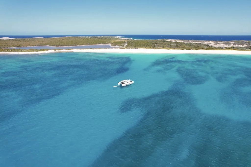 Galaxy catamaran anchored off Scrub Island, showcasing the islands gorgeous beach as well as its natural lagoon.