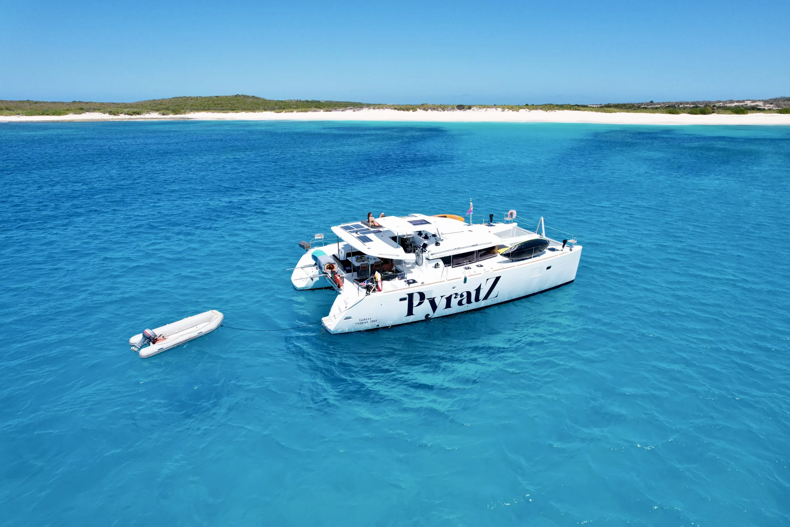 Galaxy motor catamaran anchored off the coast of Scrub Island, Anguilla with its perfect white sand beach in the background