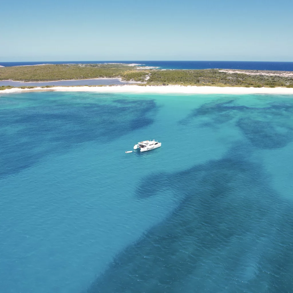 Galaxy catamaran anchored off Scrub Island surrounded by its stunning beach and beautiful calm and blue waters.