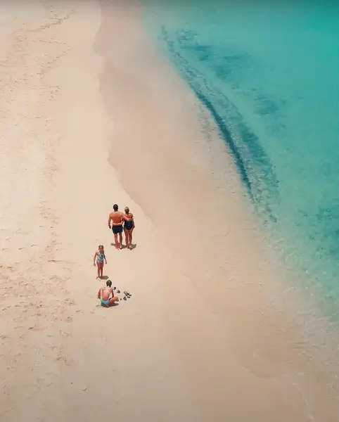 Family with two kids walking on a beach from St Maarten