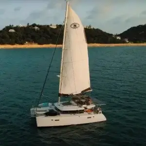 Sailing catamaran Amari sailing around the Caribbean island of St Martin as seen from a drone