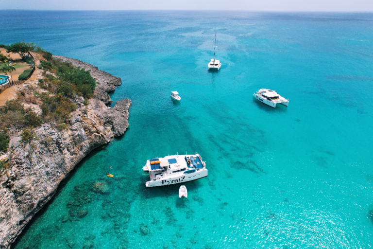 Motor catamarans from Pyratz anchored near the coast as seen from a drone