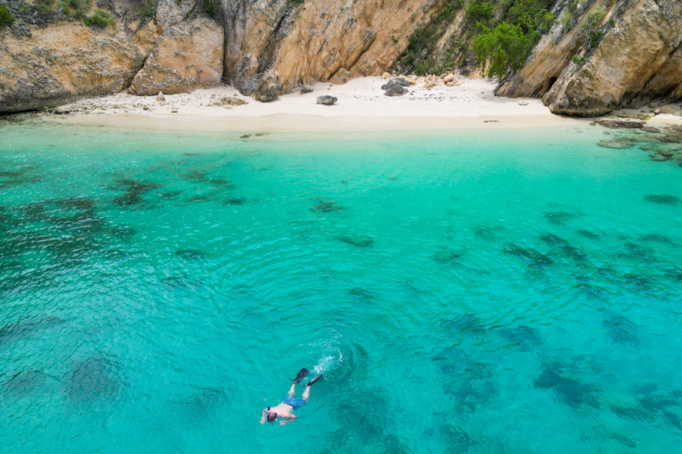 Secret cove in Anguilla with a person snorkeling as seen from a drone shot
