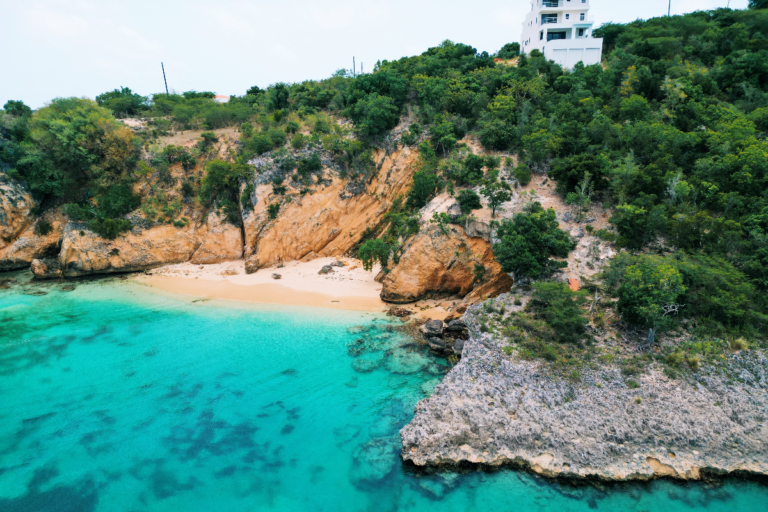 Secret cove in Anguilla as seen from a drone, with a building on top of the cliff