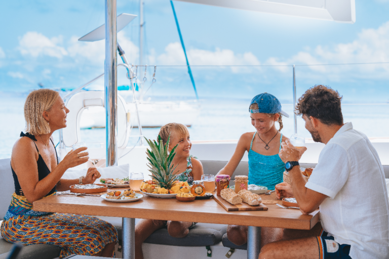 Family having breakfast onboard our sailing catamaran during an overnight charter in St Martin
