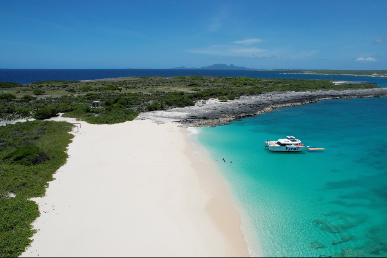 Motor catamaran from Pyratz anchored on a bay as seen from a drone shot