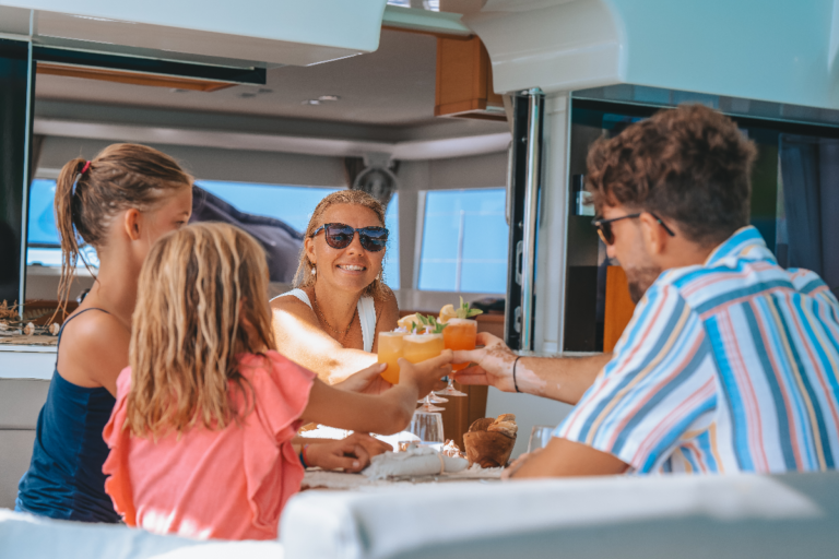 Family of two adults and two kids toasting during lunch onboard our boats