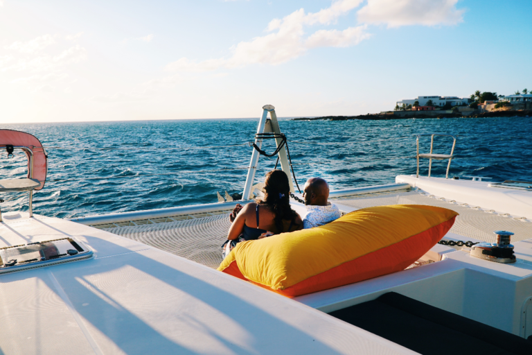 Couple lying on a bean bag on the deck of our catamaran during our sunset boat charter